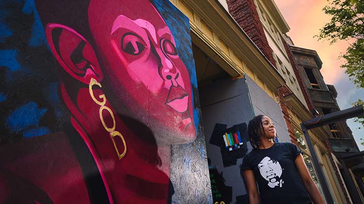 Erica Jones standing in front of her mural.