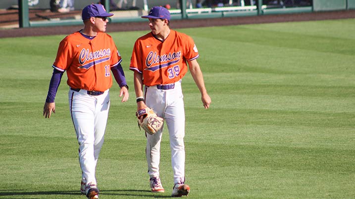Two Clemson baseball players walking together on a baseball field.