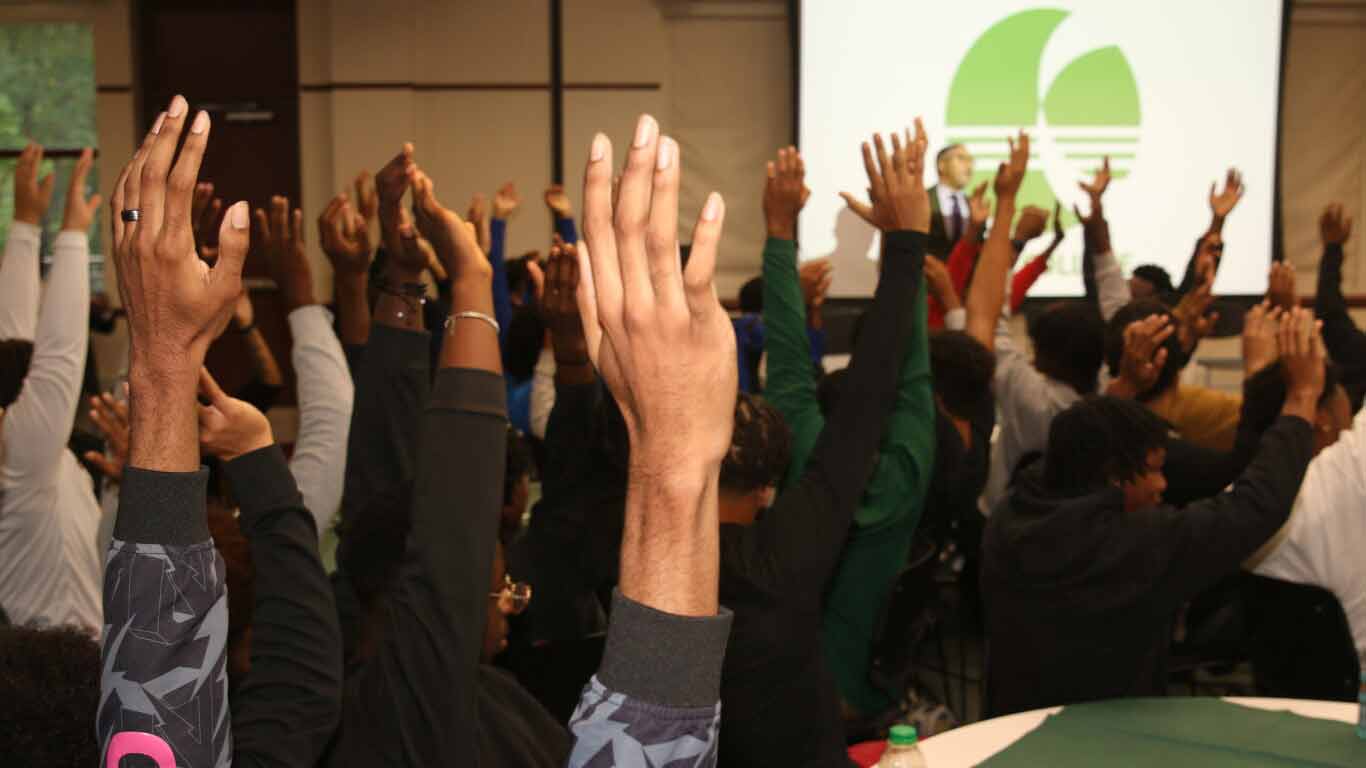 Hands raised at an indoor event.