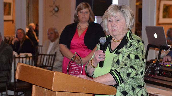 Woman at a podium holding a microphone.