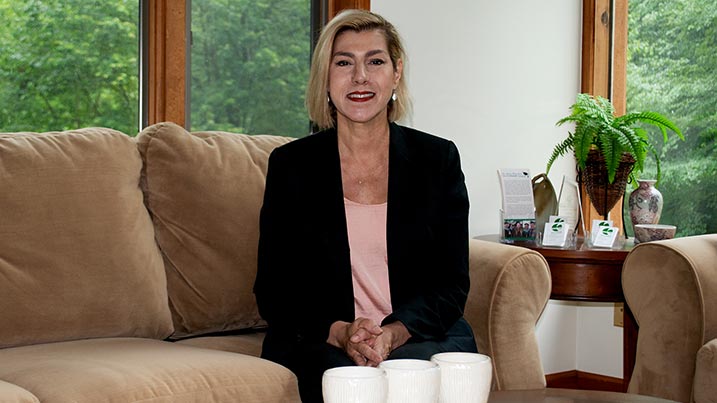 Karen Uricoli sitting in the living room of the Cedar House.