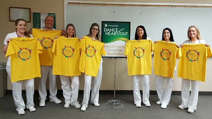 Nursing honor society students holding event t-shirts