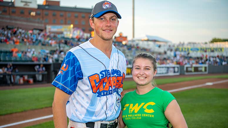 Photo of Samantha Kohl standing next to an IronBirds baseball player.