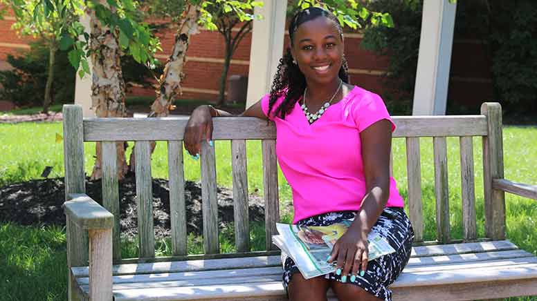 Sheena Butler sitting on bench in quad