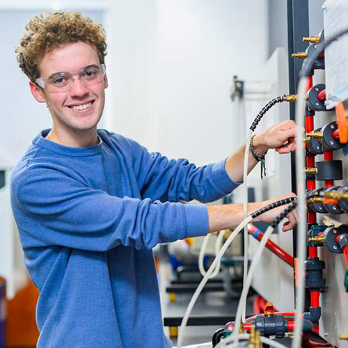Cecil College male engineering student in engineering lab with control boards
