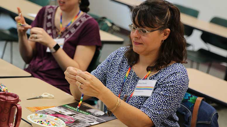 Woman making a rainbow bead bracelet