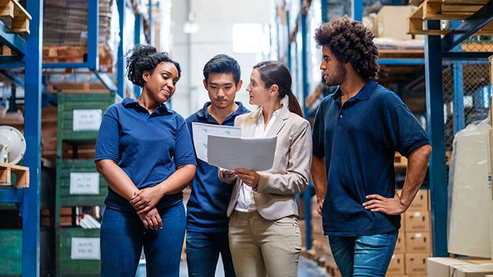 This image conveys the message of Cecil's Supply Chain Management Program. It shows the inside of a warehouse with people discussion the work.