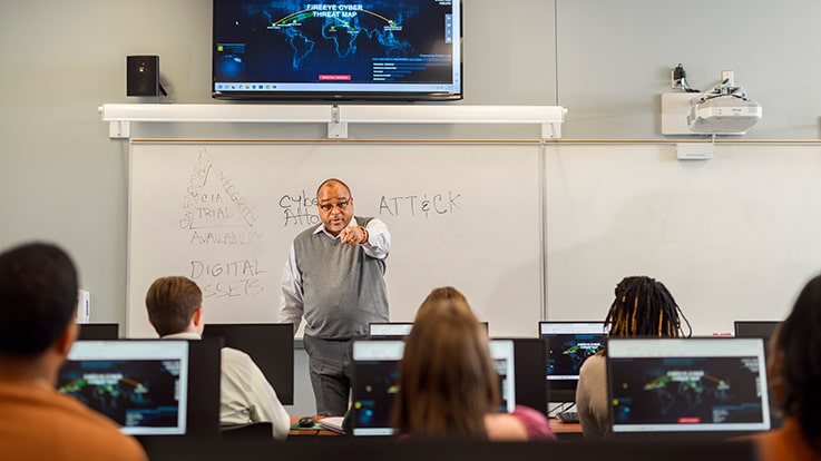 A teacher at the front of a classroom.