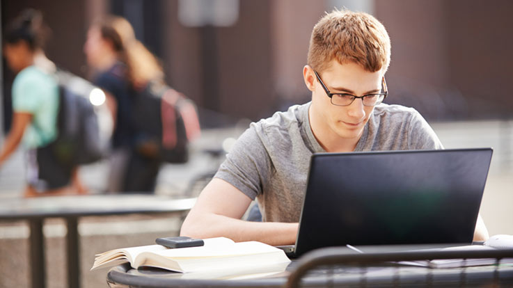 Student using a laptop outside.