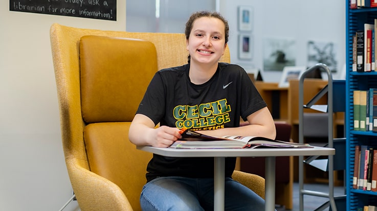 A student with a book in the library.